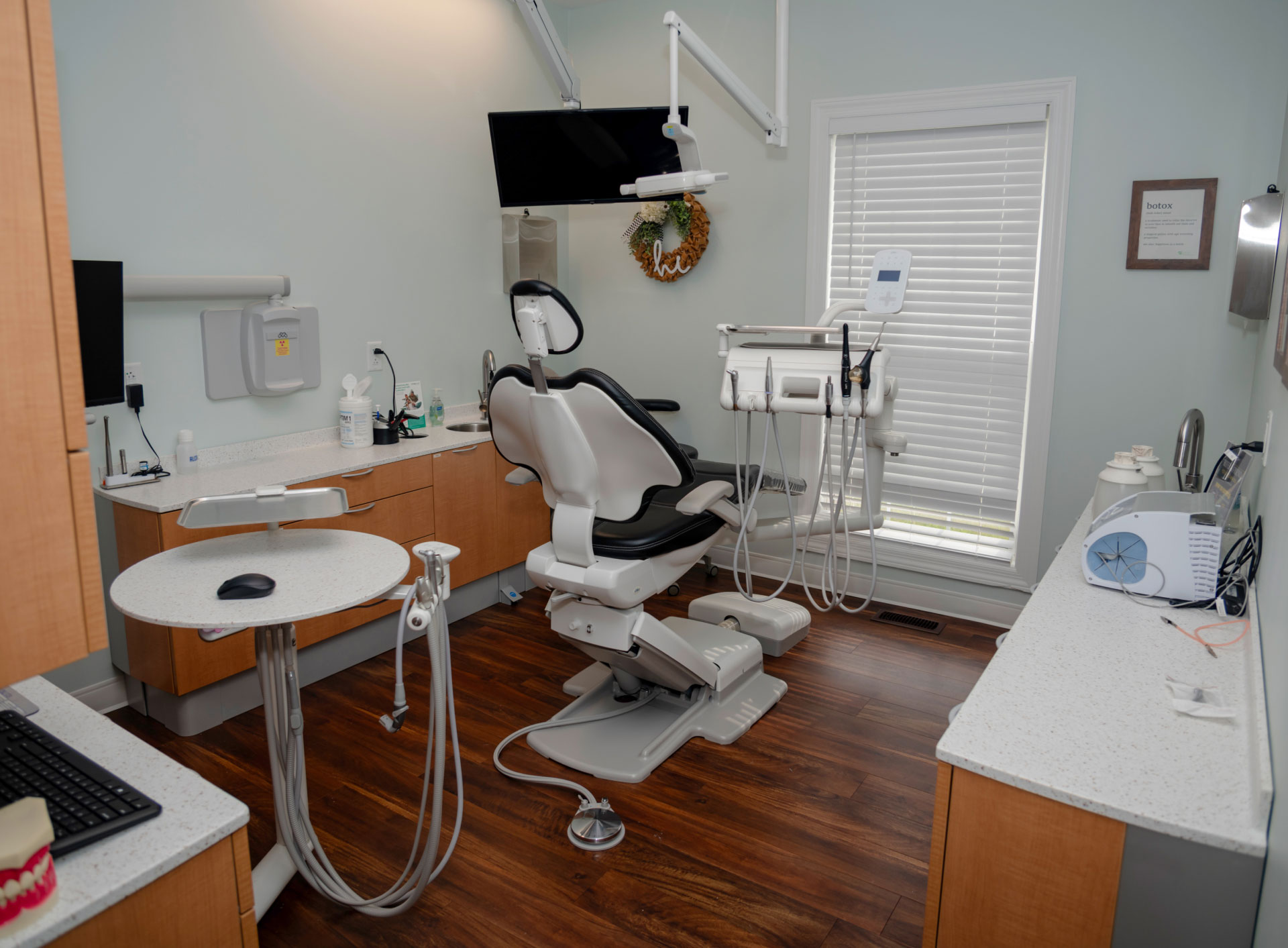 exam room with cabinets and dental chair and equipment facing window